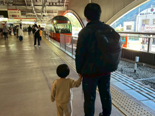 箱根湯本駅に到着し、ロマンスカーを背景に記念撮影をする筆者と家族