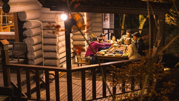 ログコテージ茶臼の森の屋根付きテラスでBBQを楽しむ家族