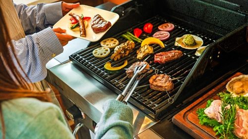 WHITE LAMPの客室デッキにあるプライベートテラスで友人とBBQを楽しむ様子